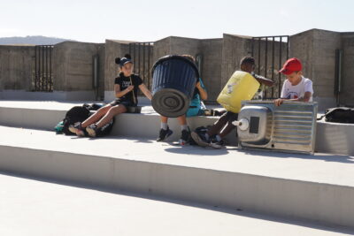 des enfants dans l'amphithéâtre de plein air font du son avec des poubelles et des éviers